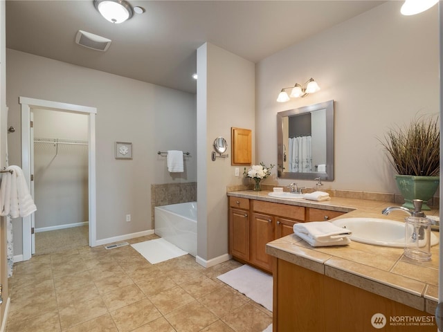 full bath featuring double vanity, a spacious closet, a sink, and a bath