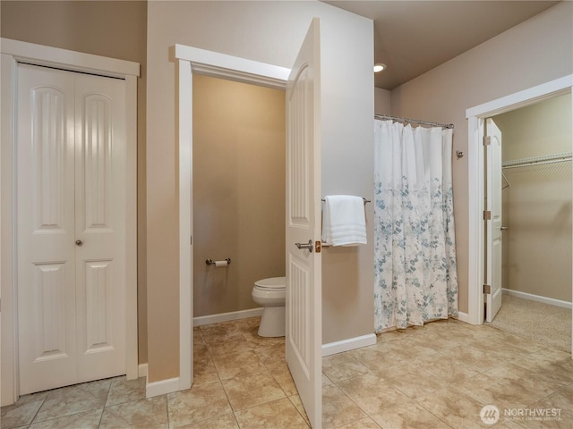 full bath featuring toilet, curtained shower, tile patterned flooring, and baseboards