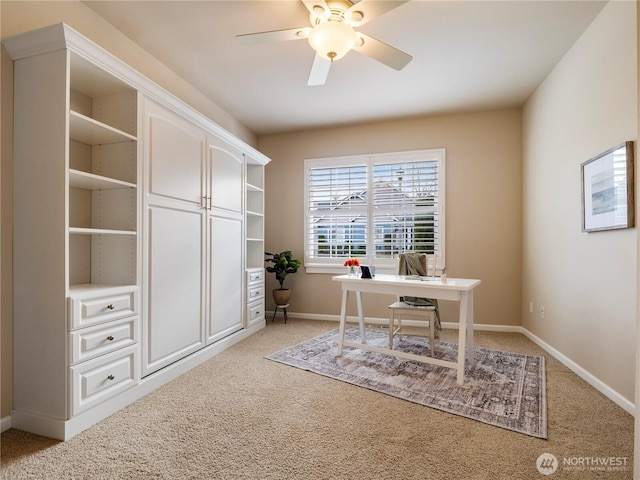 office area featuring light carpet, ceiling fan, and baseboards