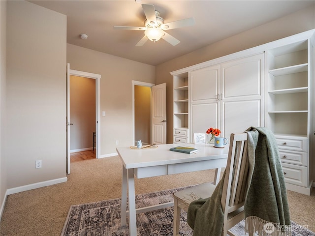 office with ceiling fan, light carpet, and baseboards