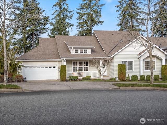 view of front of property featuring a garage, a shingled roof, a porch, and concrete driveway