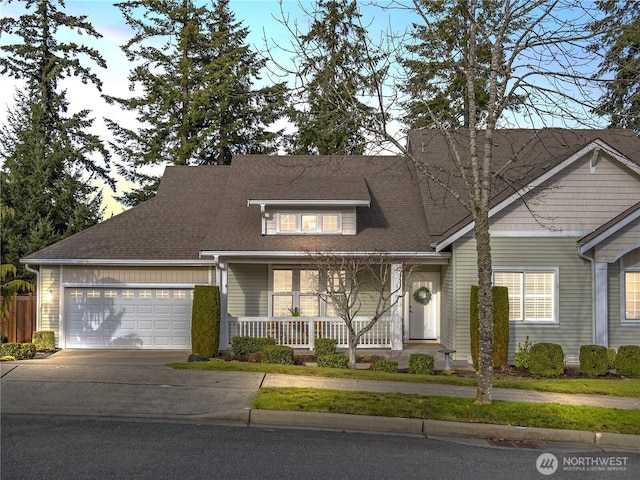 view of front of home with driveway, a shingled roof, a chimney, an attached garage, and covered porch