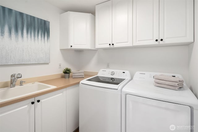 clothes washing area with a sink, cabinet space, and separate washer and dryer