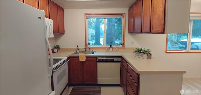 kitchen with light countertops, white appliances, and brown cabinets