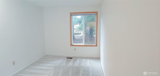 carpeted empty room featuring visible vents