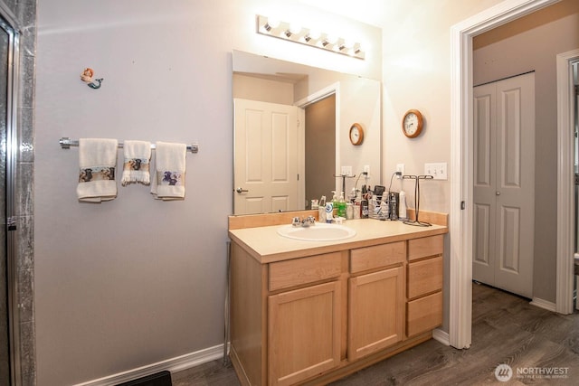 full bath with vanity, baseboards, and wood finished floors