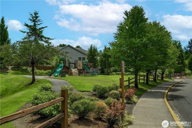 community jungle gym featuring a yard and fence