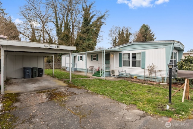 view of front facade featuring ac unit, driveway, fence, a front yard, and a carport