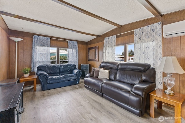 living area with lofted ceiling with beams, a textured ceiling, a wall unit AC, light wood-style floors, and wood walls