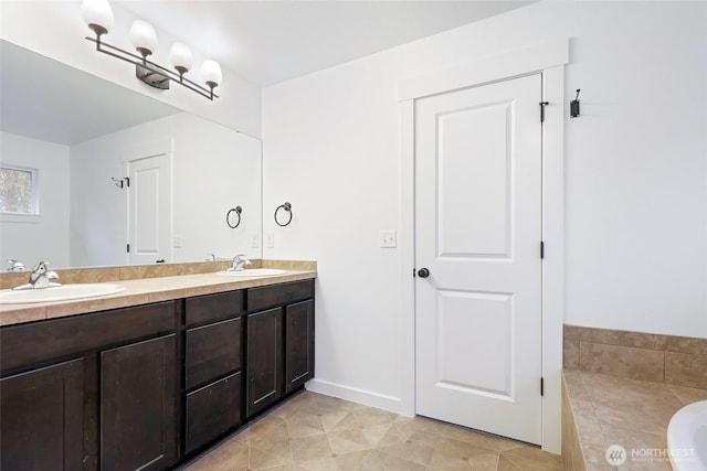 bathroom featuring baseboards, a sink, a bath, and double vanity