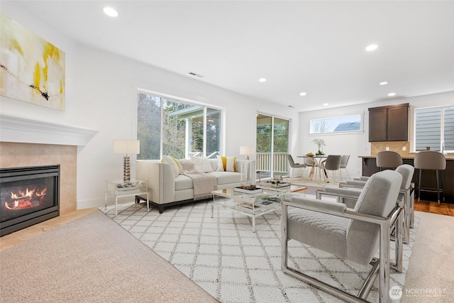 living room featuring a wealth of natural light, visible vents, a tile fireplace, and recessed lighting