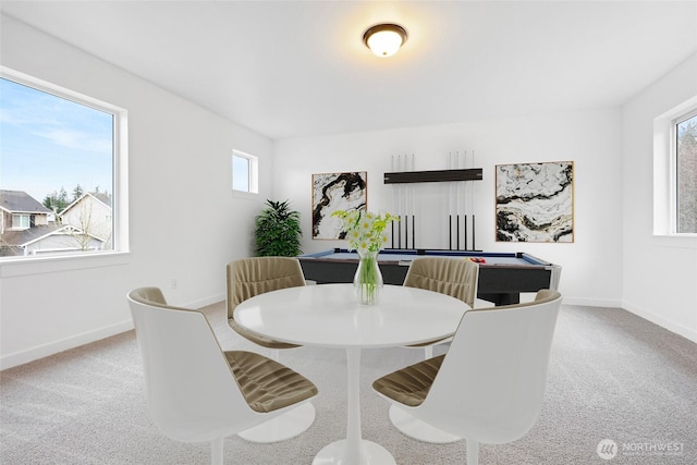 dining room featuring baseboards and light colored carpet