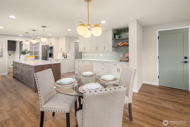 dining space with recessed lighting, baseboards, and wood finished floors