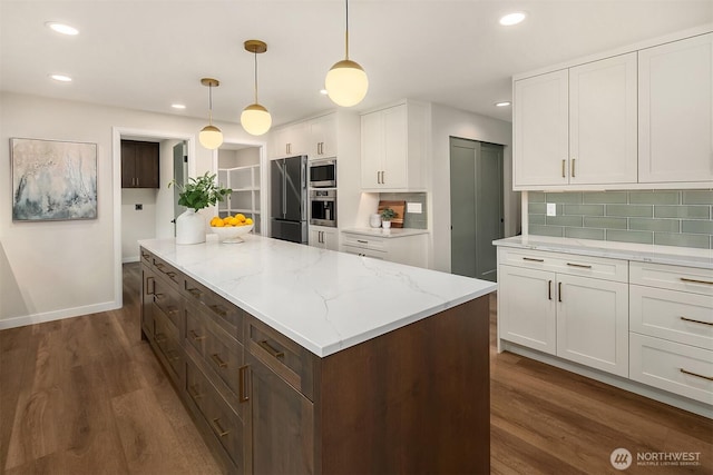 kitchen with white cabinetry, appliances with stainless steel finishes, decorative backsplash, a center island, and dark wood finished floors