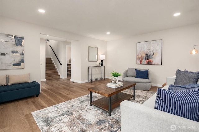 living area with recessed lighting, stairway, and wood finished floors