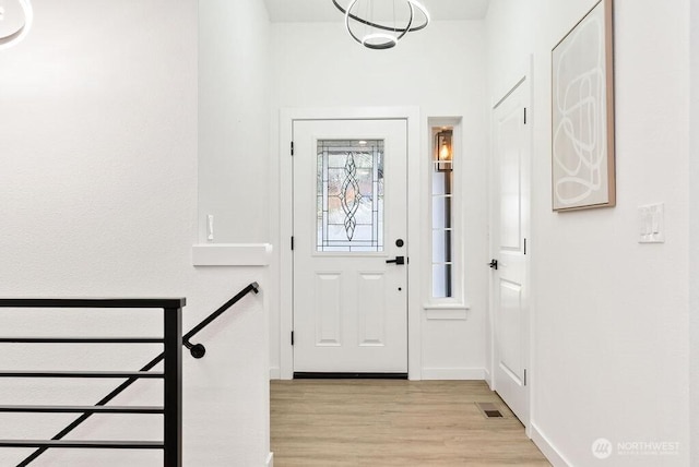 entryway with light wood-style floors, visible vents, and baseboards