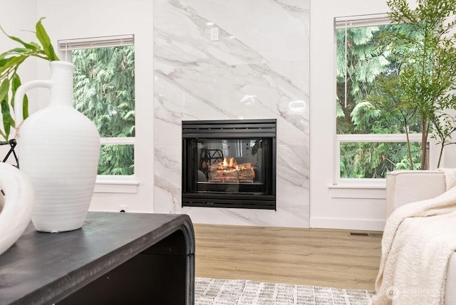 interior details featuring a high end fireplace, visible vents, and wood finished floors