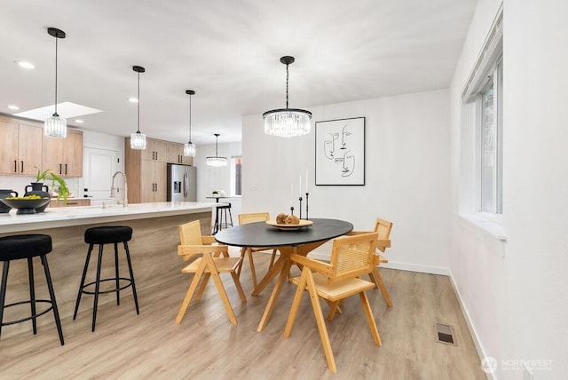 dining space with visible vents, baseboards, light wood-style flooring, a chandelier, and recessed lighting