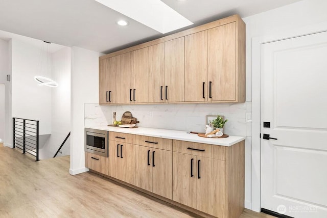 bar with light wood-type flooring, tasteful backsplash, stainless steel microwave, and recessed lighting