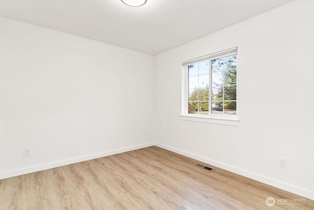 unfurnished room featuring light wood-style floors, baseboards, and visible vents