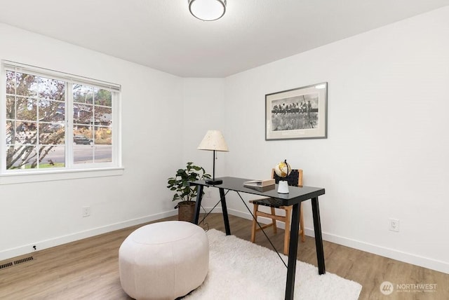 home office featuring baseboards, visible vents, and wood finished floors