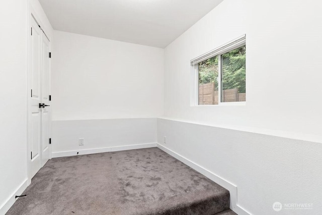 carpeted empty room with baseboards