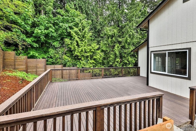 wooden terrace with a fenced backyard