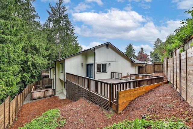 rear view of house featuring a fenced backyard and a deck