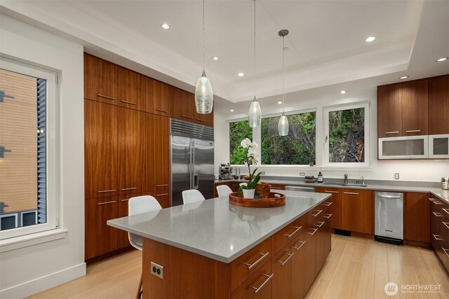 1514 Alki Ave SW, Seattle, WA 98116 - kitchen with built in fridge, modern cabinets, white microwave, light wood-style floors, and a kitchen island