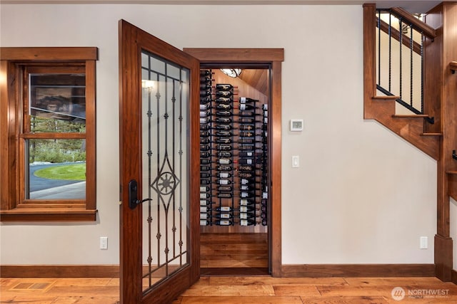 wine area featuring wood-type flooring, visible vents, and baseboards