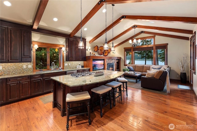 kitchen with light wood finished floors, decorative backsplash, a breakfast bar, and a center island