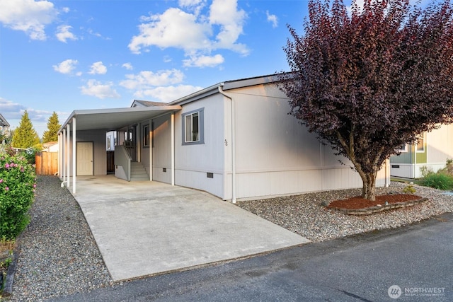 view of home's exterior featuring crawl space, driveway, an attached carport, and entry steps