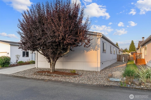 view of front of home with concrete driveway and fence