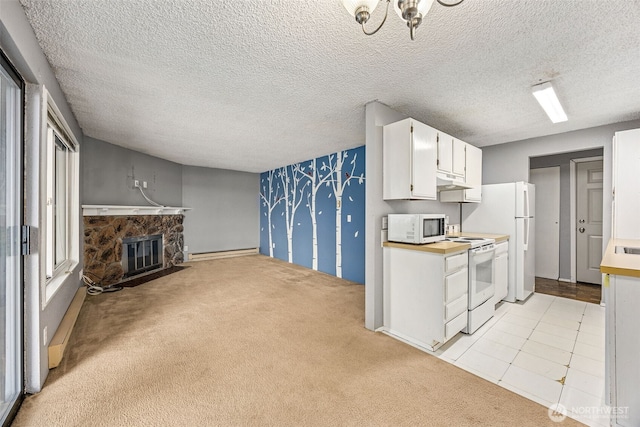 kitchen with a baseboard heating unit, light carpet, a stone fireplace, white cabinets, and white appliances