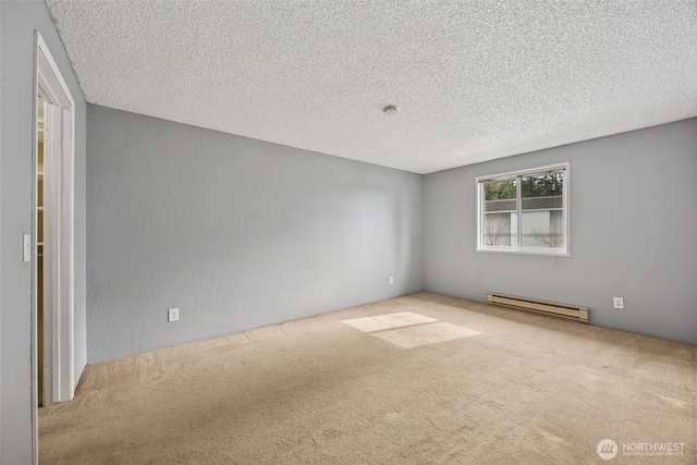 carpeted spare room with a textured ceiling and a baseboard heating unit