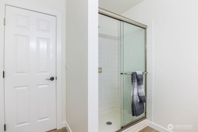full bath with a shower stall and baseboards