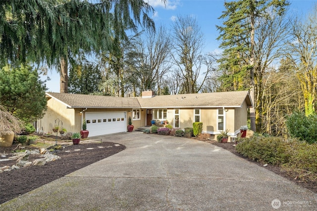 ranch-style house with a garage, concrete driveway, and a chimney