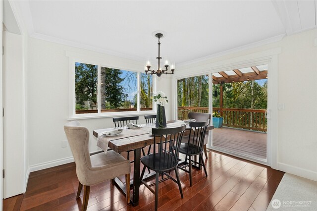 dining room featuring ornamental molding, hardwood / wood-style floors, and a notable chandelier