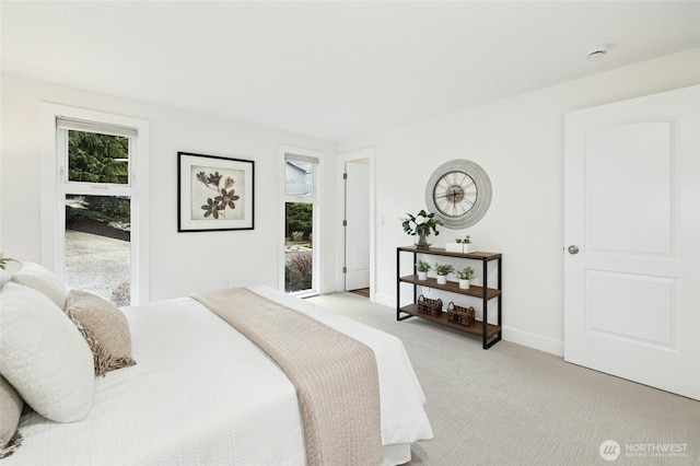 bedroom with light carpet and baseboards