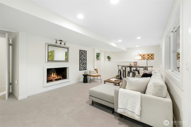 living area featuring recessed lighting, light carpet, a fireplace, and baseboards