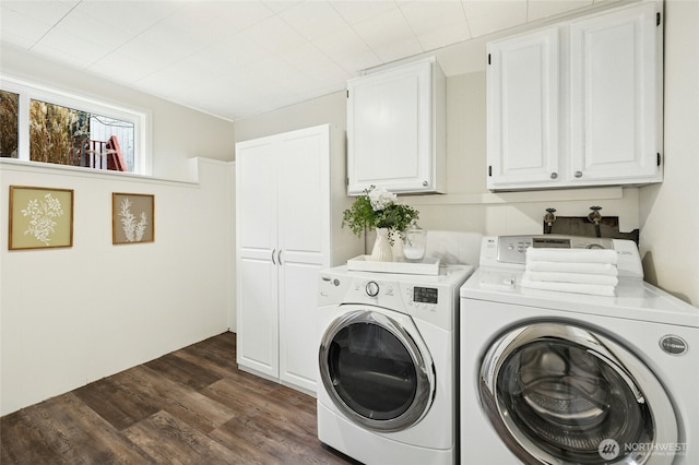 clothes washing area featuring cabinet space, separate washer and dryer, and dark wood-type flooring