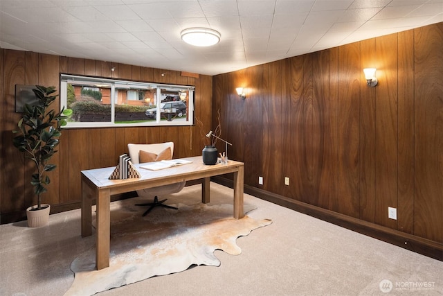 office space featuring carpet floors, wooden walls, and baseboards