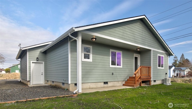 rear view of property with crawl space and a yard