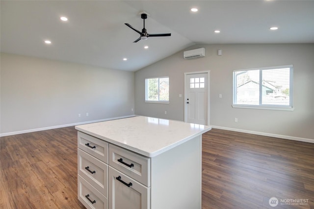 kitchen with dark wood-style floors, open floor plan, a center island, a wall mounted air conditioner, and white cabinetry