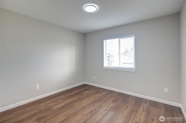 unfurnished room with dark wood-type flooring and baseboards