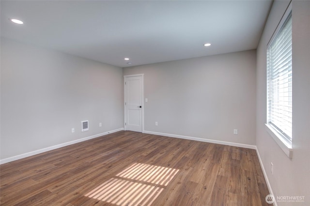 unfurnished room featuring dark wood-style floors, baseboards, visible vents, and recessed lighting