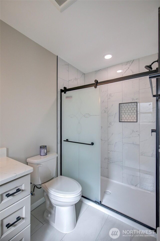 full bathroom featuring toilet, a shower stall, visible vents, and vanity