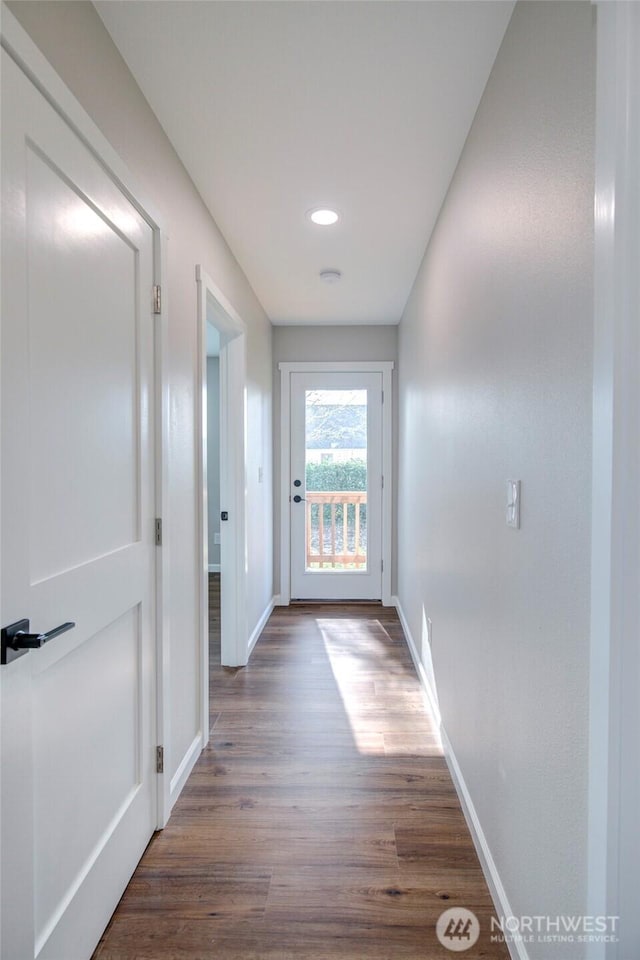 hallway featuring baseboards and wood finished floors