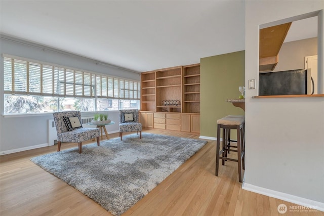 living area with light wood finished floors, a wealth of natural light, and baseboards