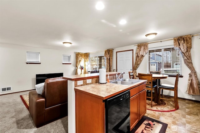 kitchen with a sink, visible vents, open floor plan, light countertops, and dishwasher